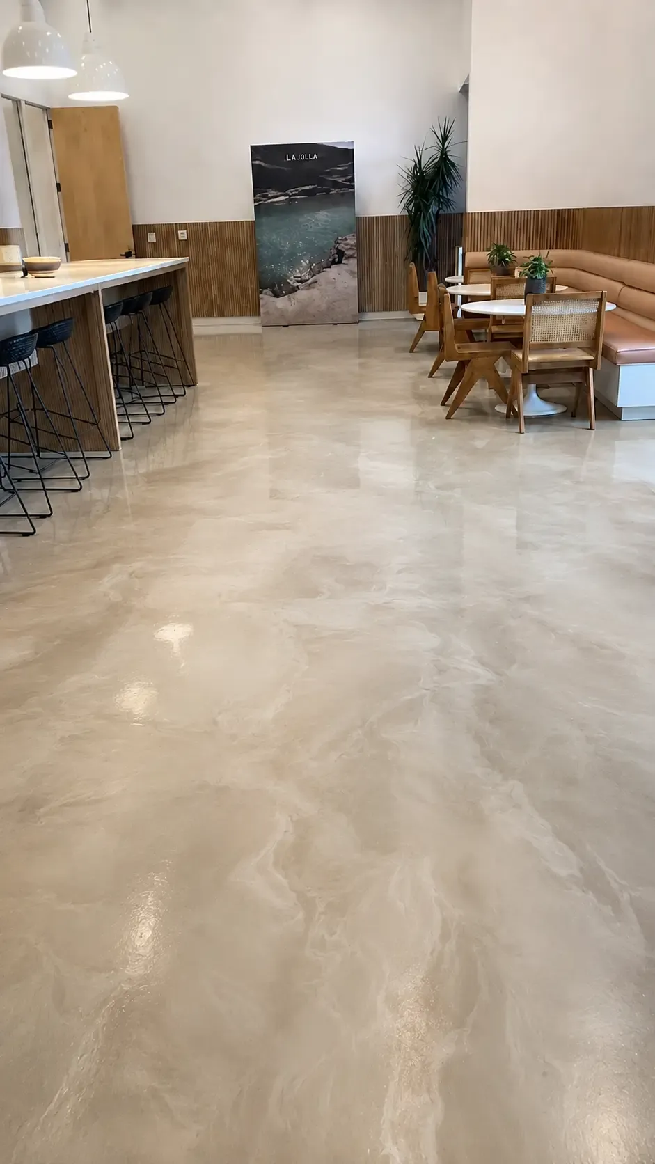 The same cafe after coating, with a cream and pearl metallic epoxy floor reflecting the pendant lights.