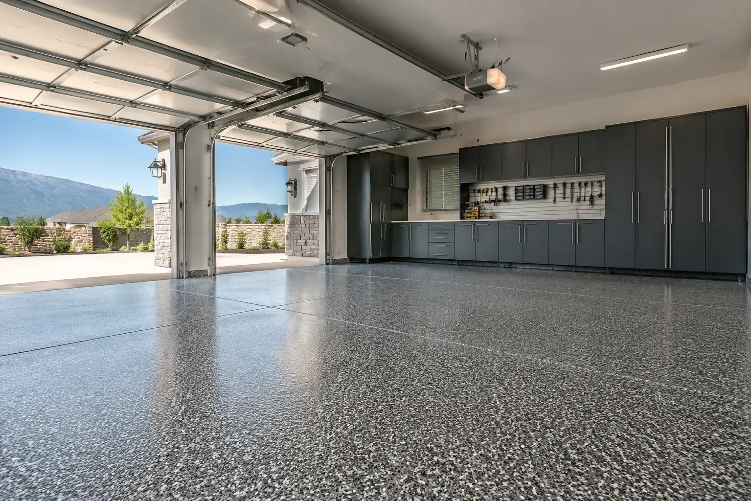 Example of a high-gloss gray flake garage floor with a polyaspartic topcoat in a three-car garage — Rancho Cucamonga, CA service area