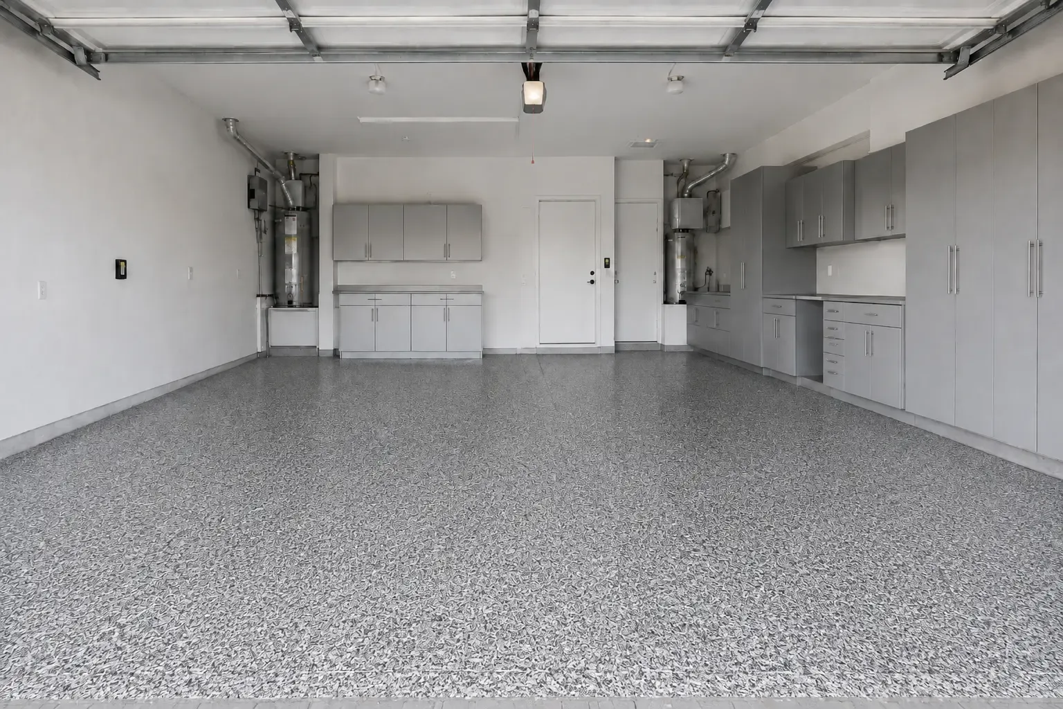 The same garage after coating, with a gray, white and black decorative flake floor and cove base.